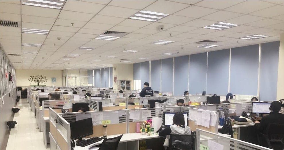 Photo capturing the interior of a VXI Guangzhou contact center, showing agents actively working at their desks