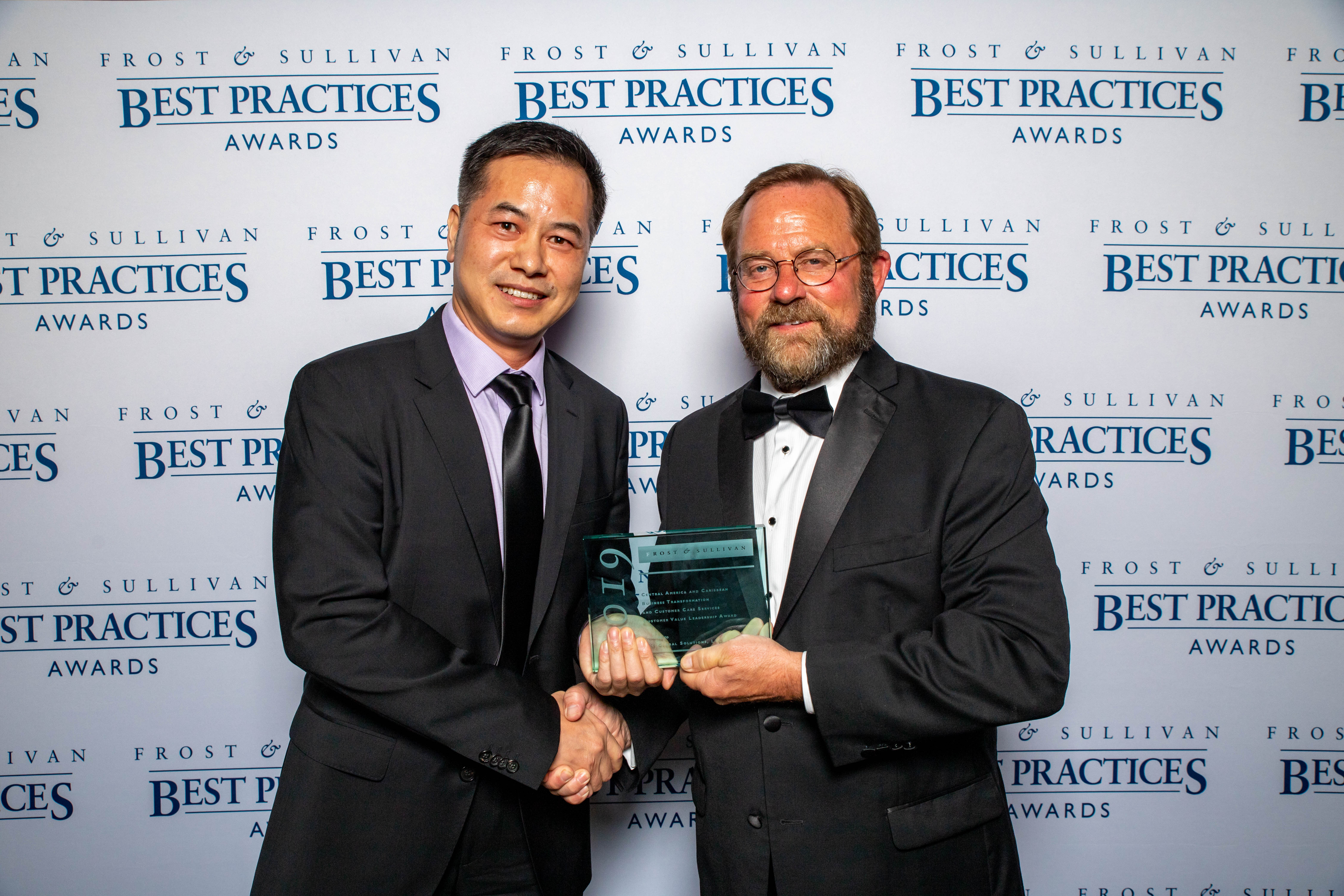 Photo showing a Frost & Sullivan representative and VXI's CEO David Zhou holding the 'Customer Value Leadership Award' at the 2019 Frost & Sullivan Best Practices Awards ceremony.