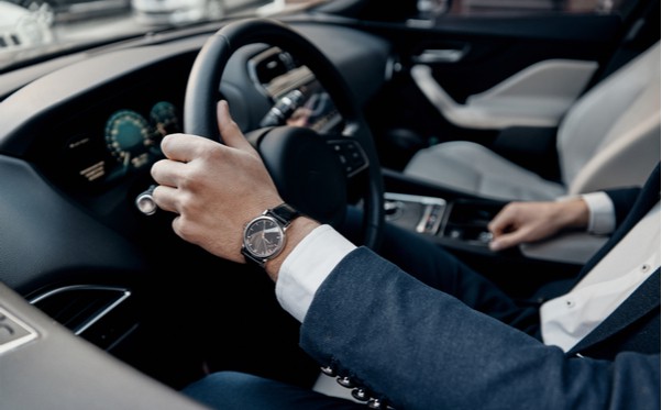 A man in a suit is driving an automotive.