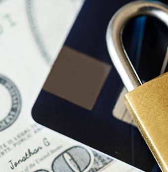 A padlock protects a stack of dollars while ensuring regulatory compliance.