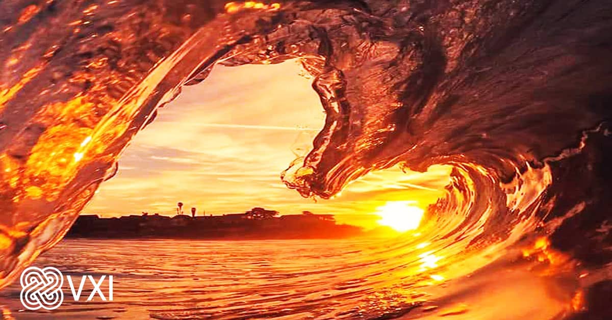 An image of a wave in the ocean at sunset.