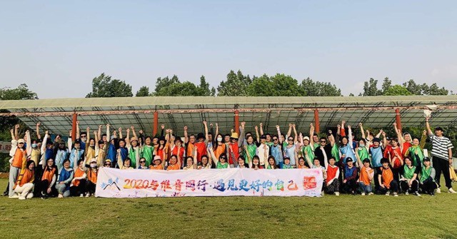 A group of people from VXI China posing for a photo with a banner