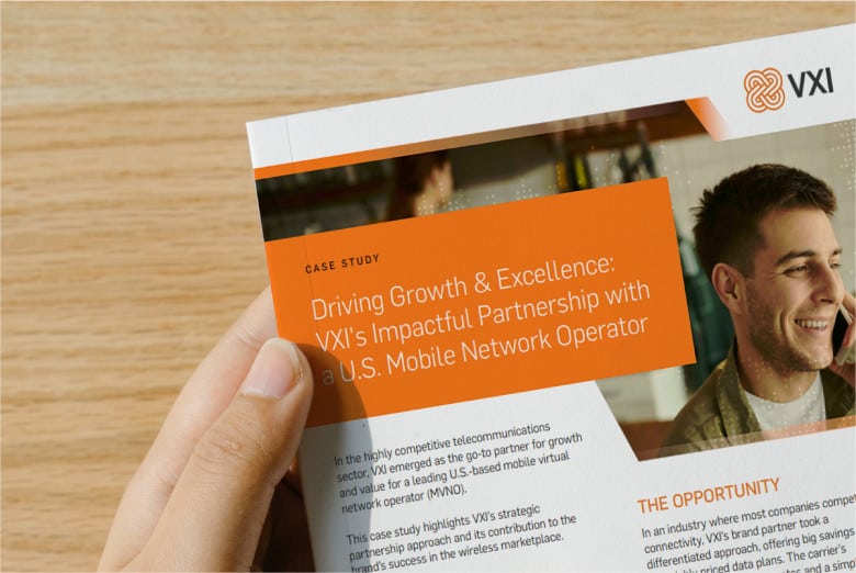 A hand holding a case study report titled 'Driving Growth & Excellence: VXI’s Impactful Partnership with a U.S. Mobile Network Operator'